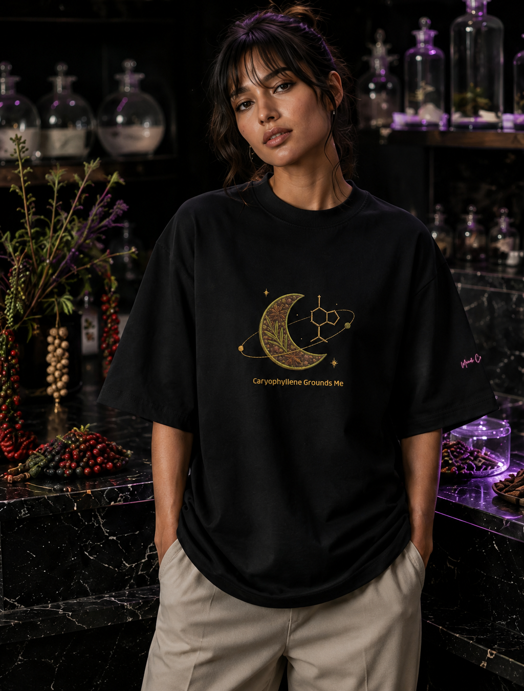 Woman wearing the black Caryophyllene Grounds Me oversized high-neck tee in a premium botanical apothecary.