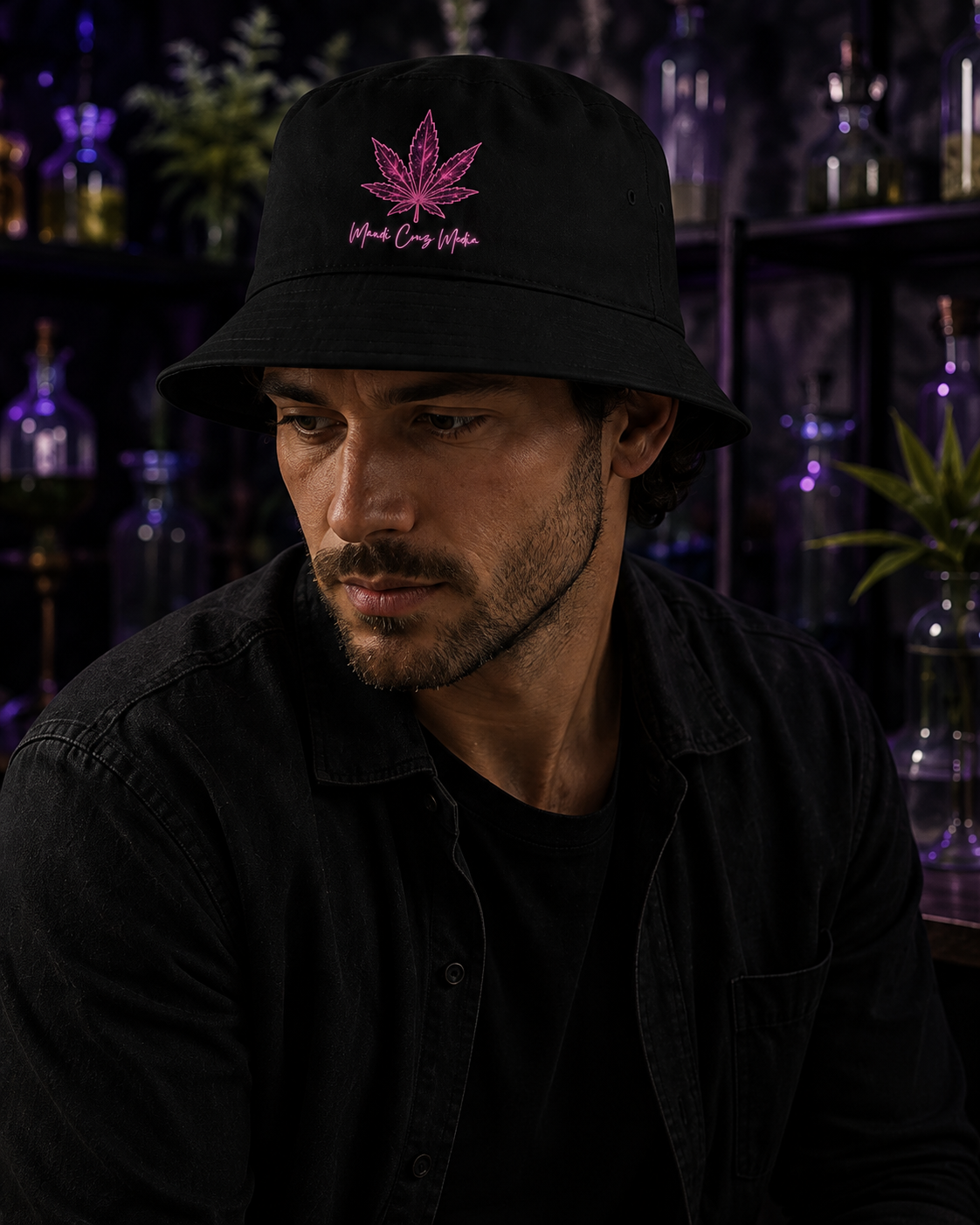 Man wearing the black Mandi Cruz Media Pink Leaf Bucket Hat in a dark botanical setting with purple ambient lighting.
