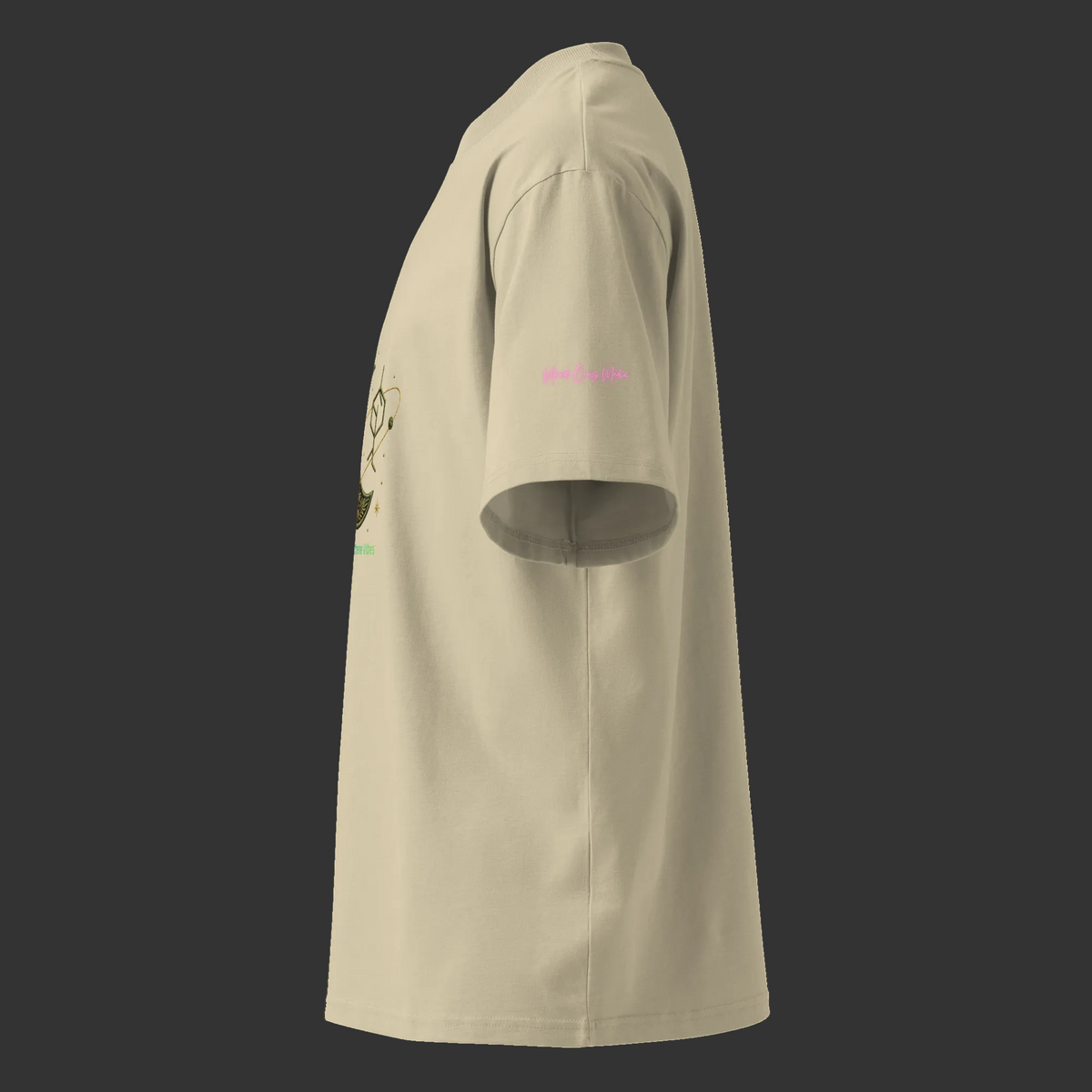 Left-side view of the stone oversized high-neck tee showing the dropped shoulder and pink Mandi Cruz Media sleeve signature.