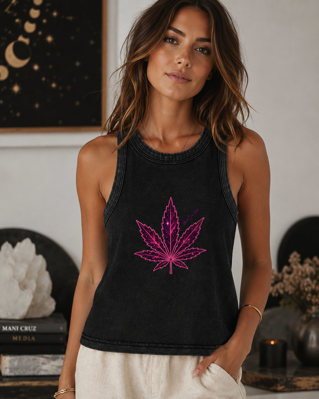 Woman wearing the washed-black Cosmic Pink Leaf fitted crop tank with neutral pants inside a sophisticated modern lounge.