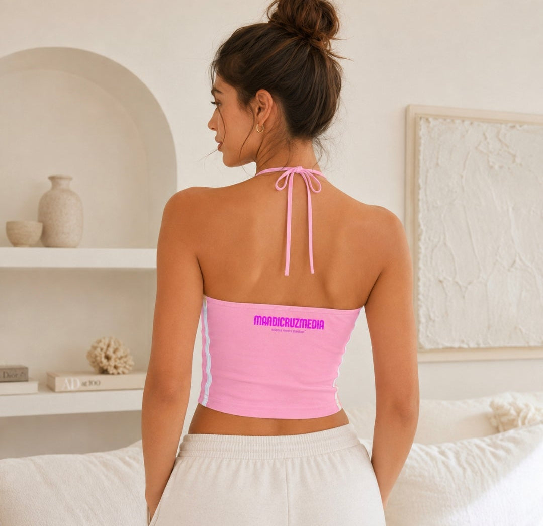 Back view of woman wearing the pink Cosmic Heart halter crop top with halter ties, white side stripes, and Mandi Cruz Media branding.