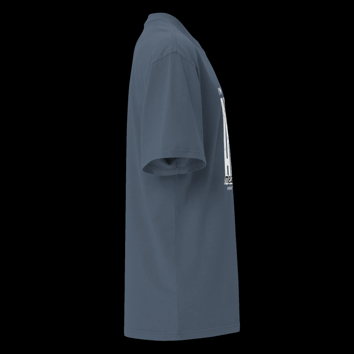 Right-side view of the faded indigo oversized tee showing its relaxed silhouette and partial statement design.
