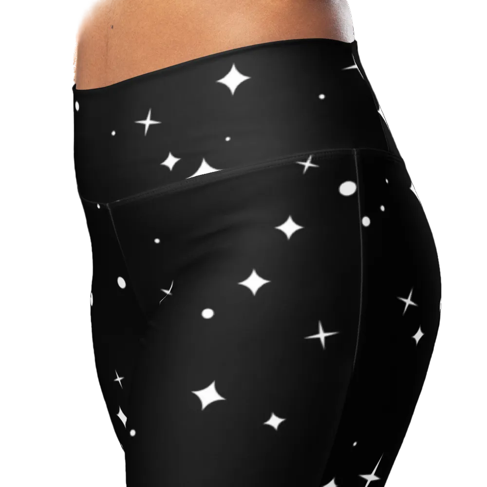 Close-up front view of the high-rise crossover waistband and white star print on black stretch fabric.