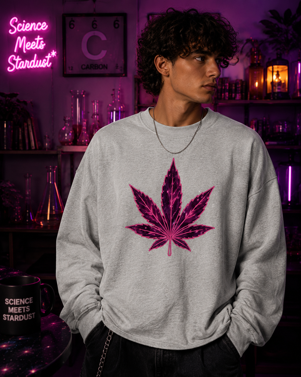 Man wearing the Flower Gray Mandi Cruz Media raw edge boxy sweatshirt with a hot-pink celestial leaf graphic in a Science Meets Stardust™ cosmic studio setting