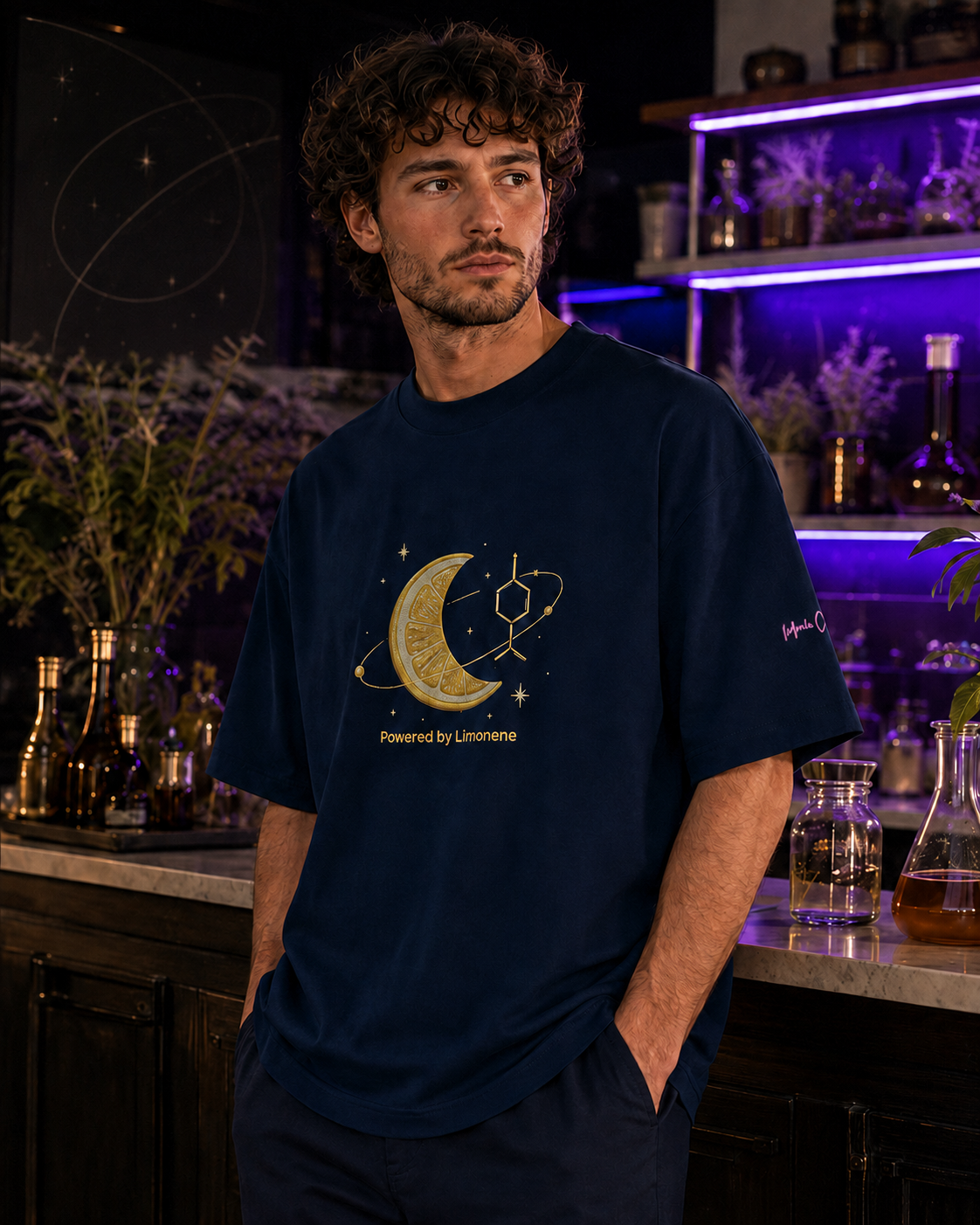 Man wearing the French-navy Powered by Limonene oversized tee in a purple-lit botanical science apothecary.