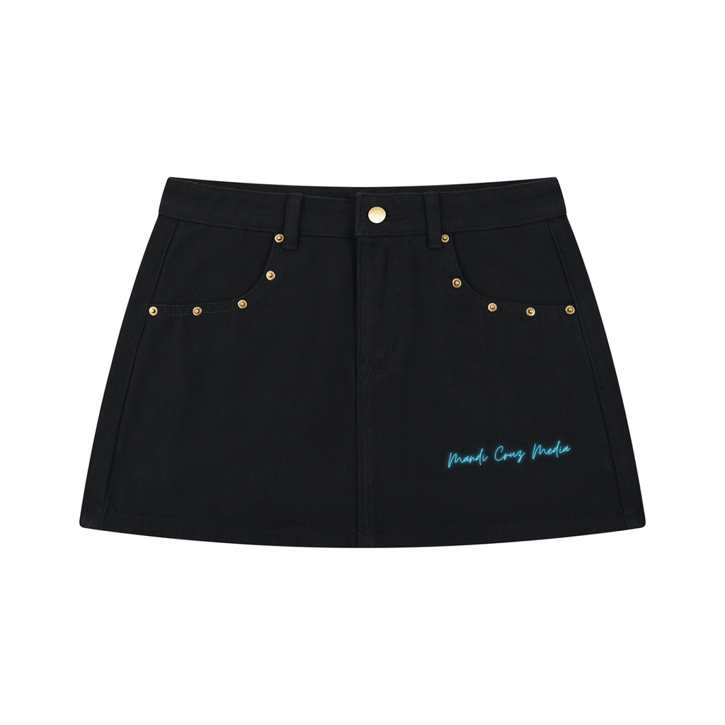 Front product view of the Electric Stardust black denim mini skirt featuring gold-tone studs, front pockets, and electric-blue Mandi Cruz Media script.
