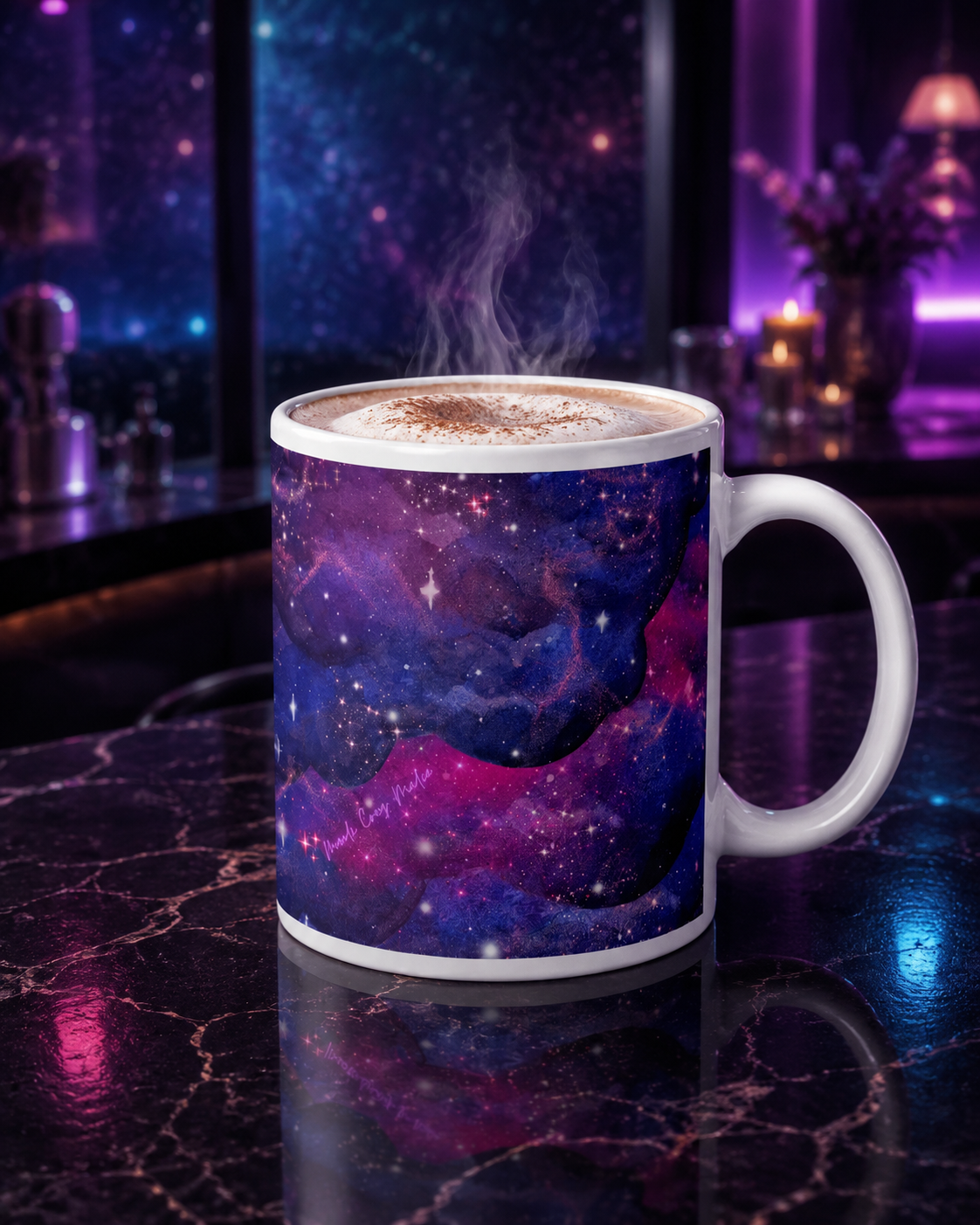 Large Nebula Mug filled with a foamy cappuccino on black marble in a violet-and-blue cosmic lounge, with the pink Mandi Cruz Media logo visible.