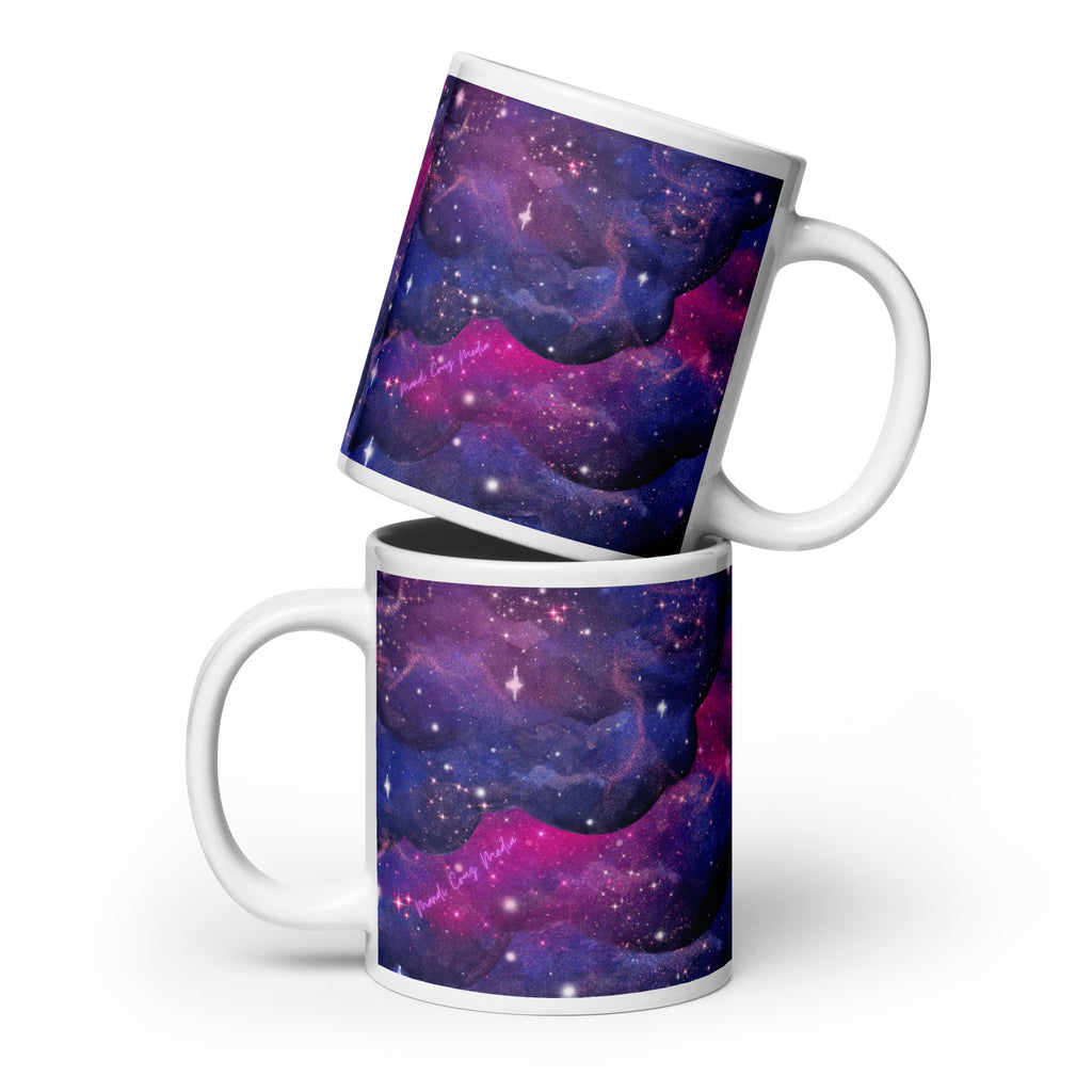 Two white 20-ounce ceramic mugs arranged together to display the purple, blue and magenta nebula wrap and pink Mandi Cruz Media script logo.