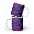 Two white 20-ounce ceramic mugs arranged together to display the purple, blue and magenta nebula wrap and pink Mandi Cruz Media script logo.