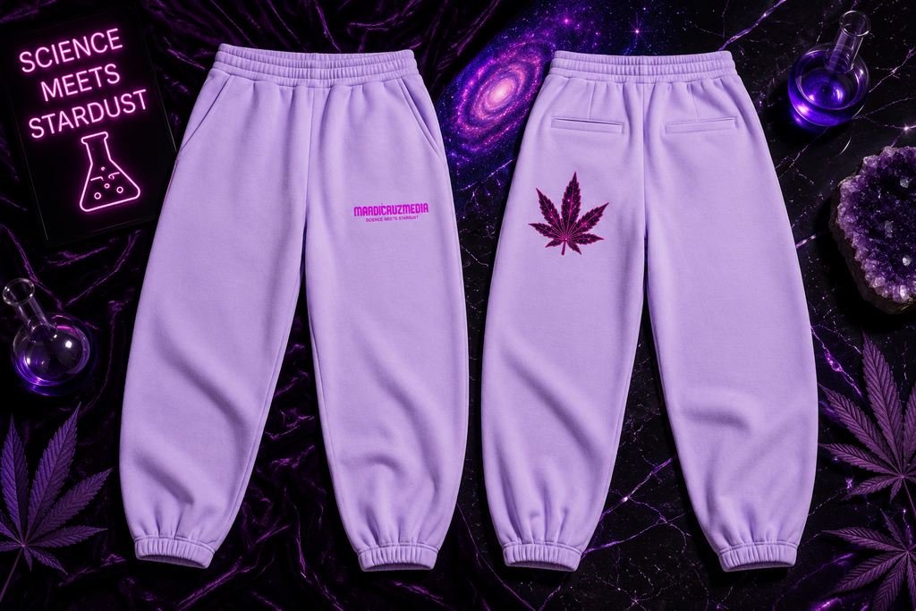 Premium flat lay of lavender Mandi Cruz Media sweatpants showing the front and back, featuring a hot pink Mandi Cruz Media Science Meets Stardust logo on the front and a pink galactic leaf graphic on the back, styled against a black and purple cosmic background.