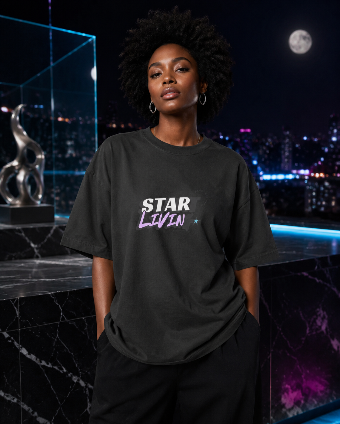 Woman modeling the washed-black Start Living oversized tee on a luxurious moonlit city rooftop.