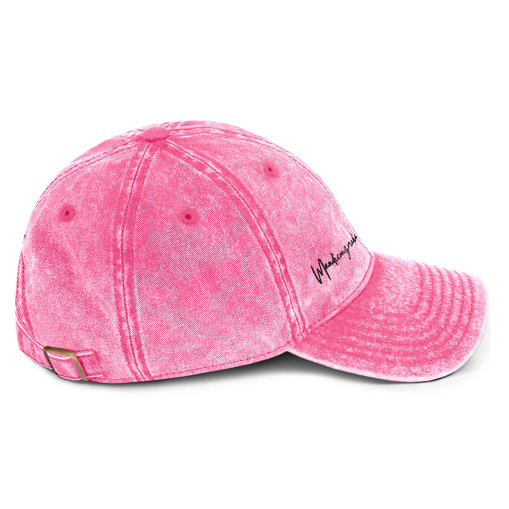 Right-side view of the pink vintage cotton twill cap with black Mandi Cruz Media signature embroidery.