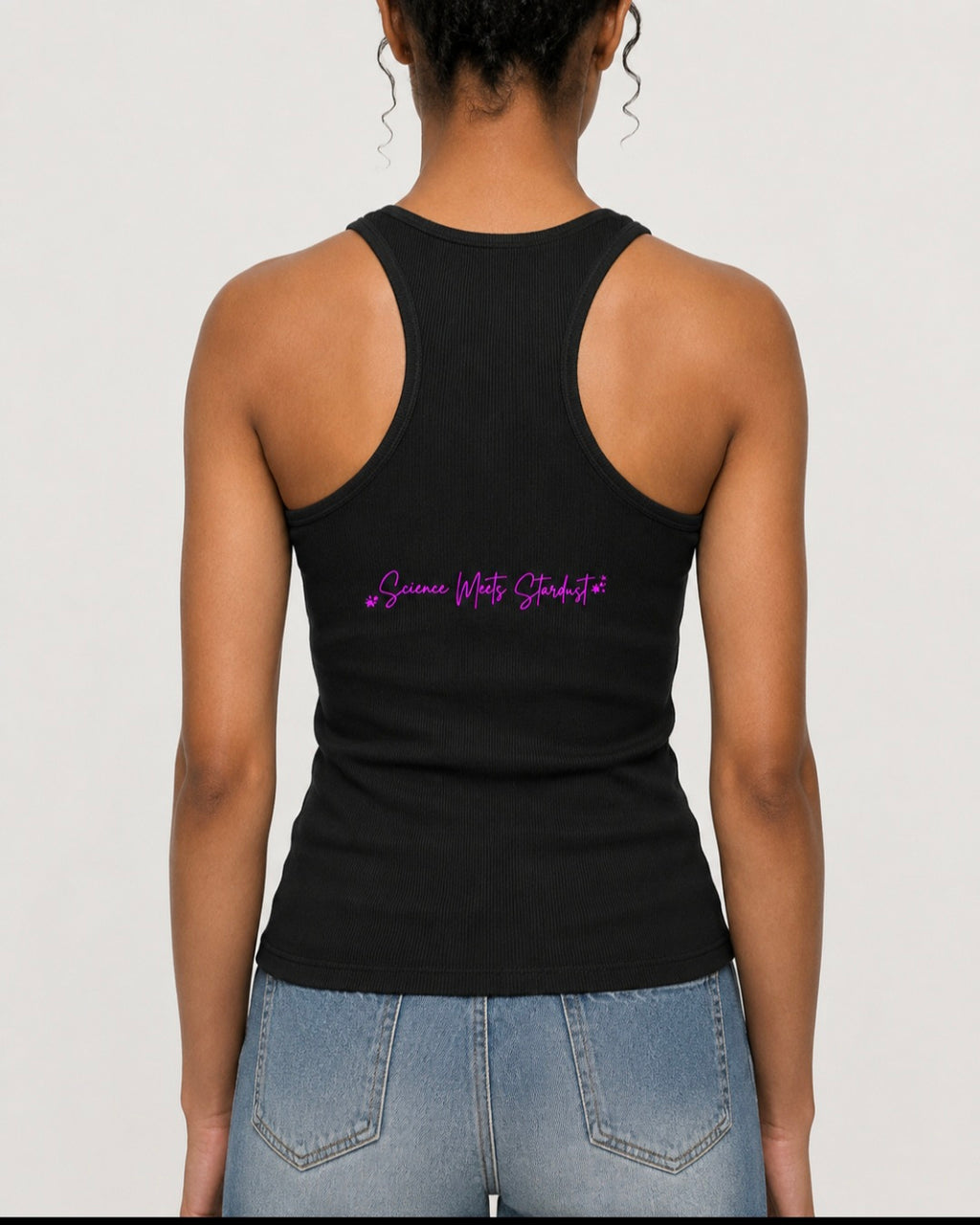 Back view of a woman wearing a black ribbed racerback tank featuring the pink Science Meets Stardust script design.