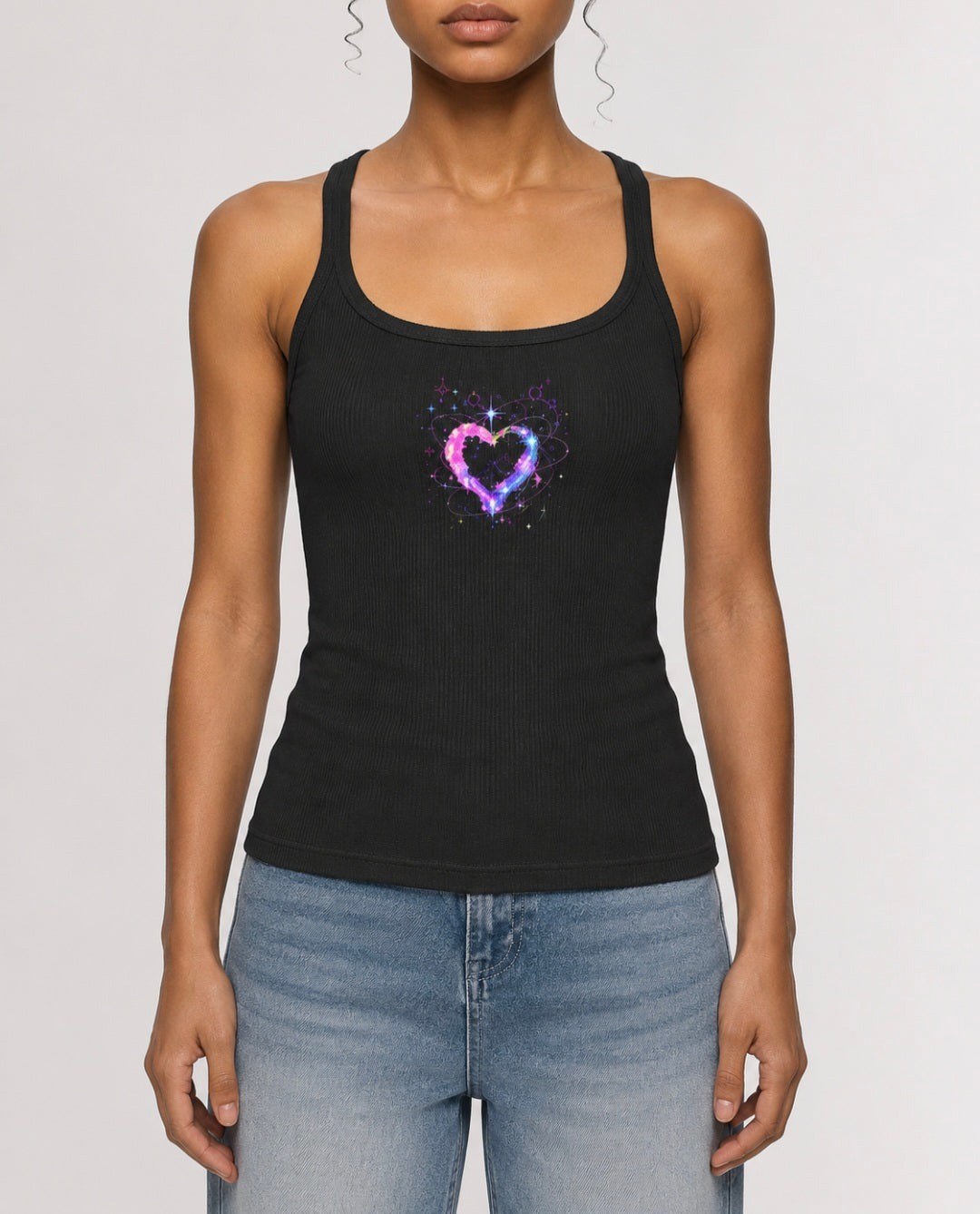 Front view of woman wearing charcoal ribbed racerback tank featuring a pink, purple and blue cosmic heart graphic by Mandi Cruz Media.