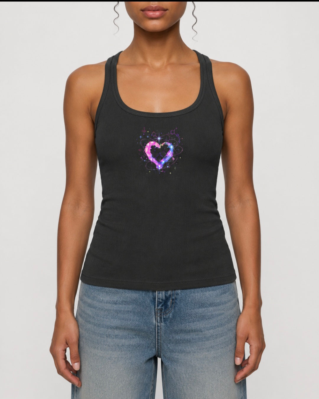 Front view of woman wearing charcoal ribbed racerback tank top featuring a colorful cosmic heart graphic by Mandi Cruz Media.