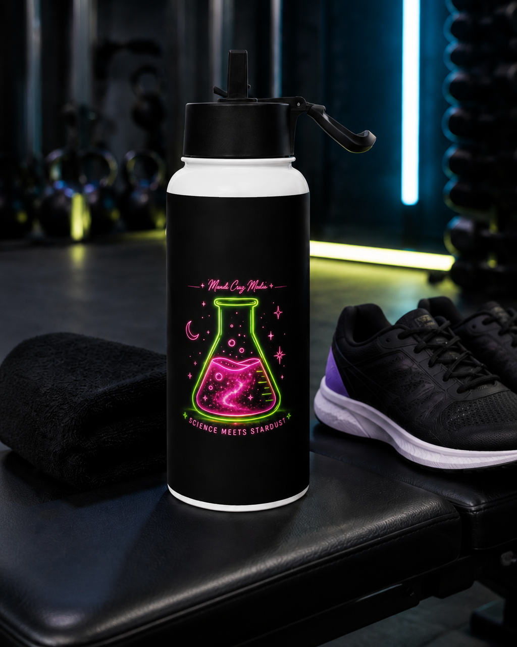 Black Science Meets Stardust water bottle displayed beside a gym towel and black athletic shoes.
