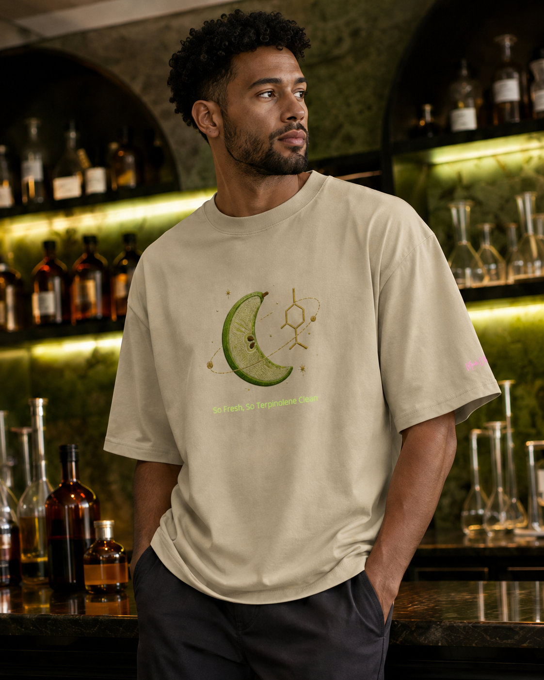 Man wearing the stone So Fresh, So Terpinolene Clean oversized tee in an upscale botanical science lounge.
