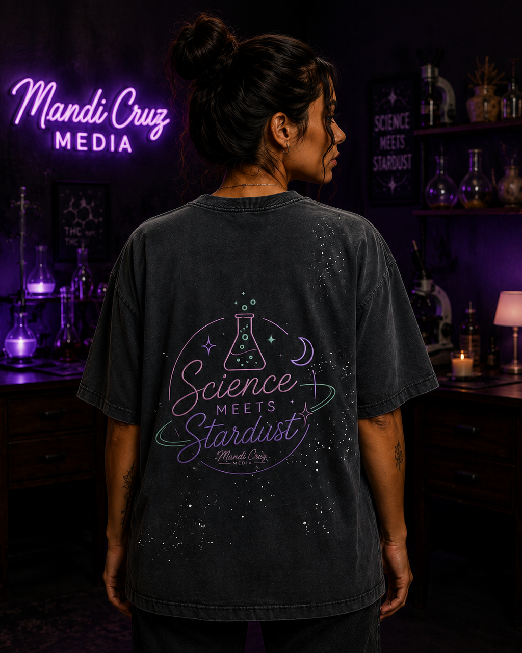 Lifestyle back view of a model wearing the black Beaker™ vintage washed T-shirt by Mandi Cruz Media showing the graphic design.