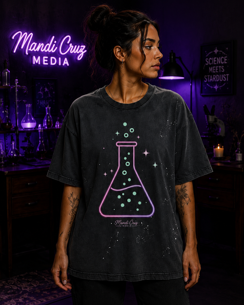 Lifestyle front view of a model wearing the gray Beaker™ paint-splatter T-shirt by Mandi Cruz Media with relaxed oversized fit.