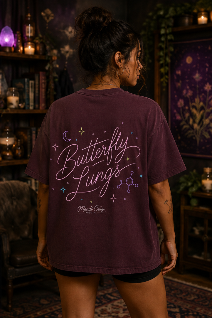 Lifestyle back view of a model wearing the Mandi Cruz Media Butterfly Lungs™ vintage washed T-shirt highlighting the signature graphic artwork.