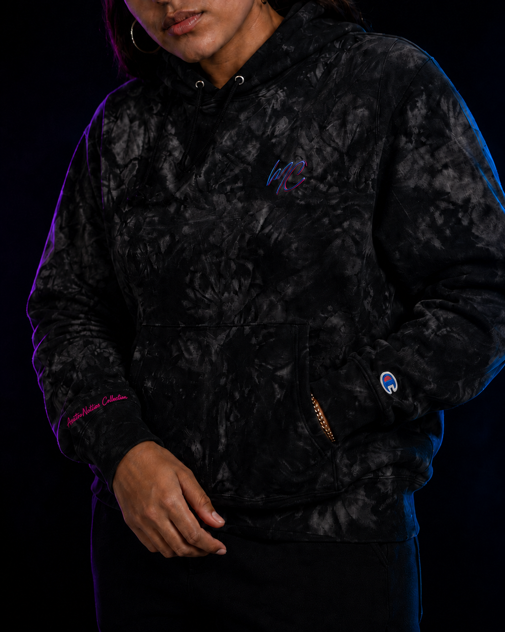Close view of the hoodie’s MC chest embroidery, AsstroNotties Collection sleeve script, kangaroo pocket and Champion cuff patch.