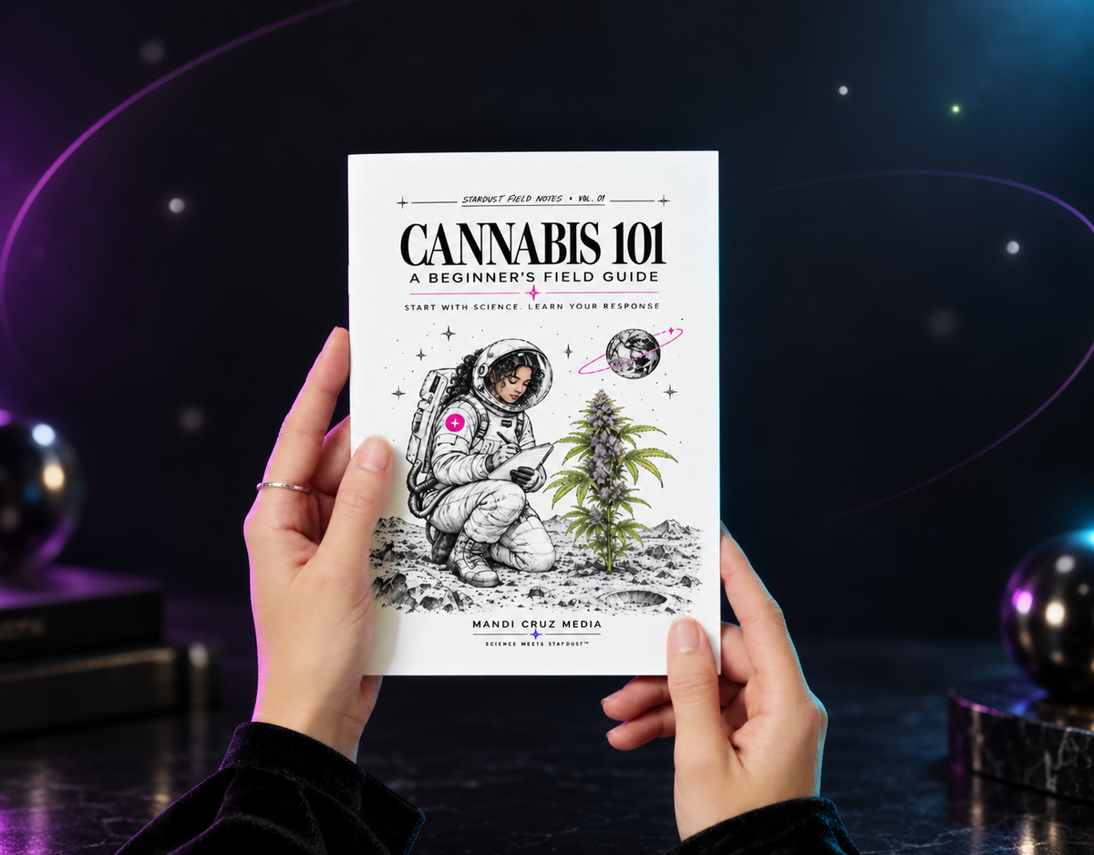 Hands holding the Cannabis 101 beginner’s field guide against a dark cosmic background.