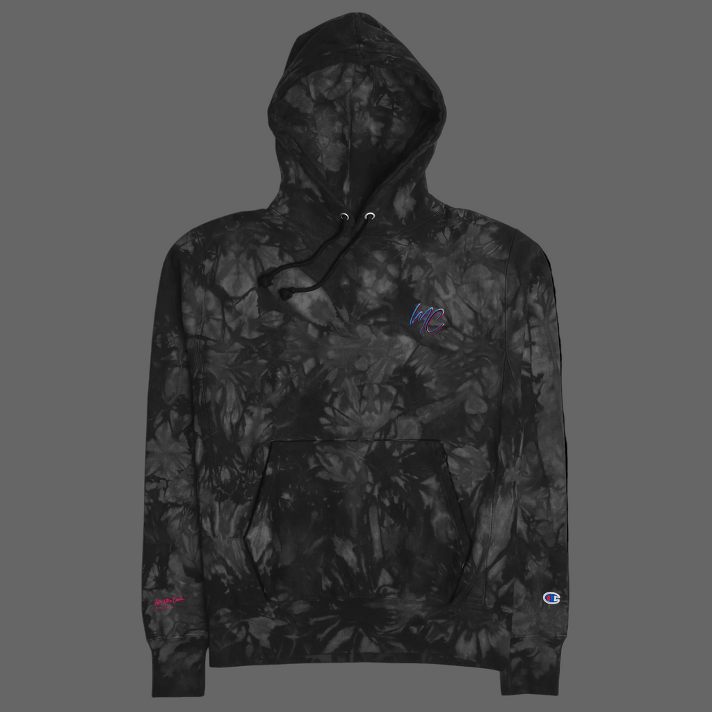 Front product view of the black-and-charcoal Champion tie-dye hoodie with MC chest embroidery and a kangaroo pocket.