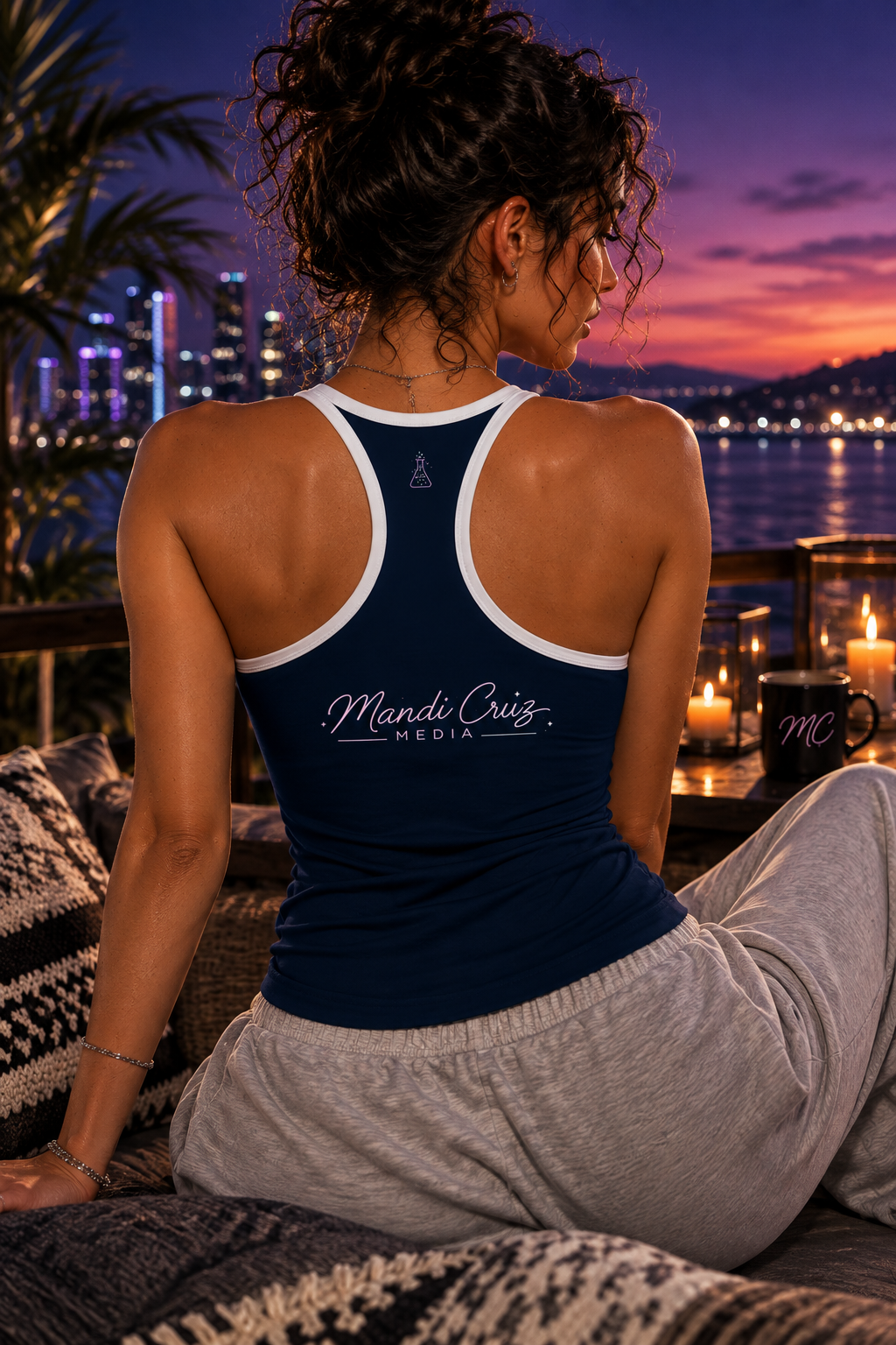 Back lifestyle view of a woman wearing the navy Neon Leaf Yoga Tank Top showing the Mandi Cruz Media script logo against a nighttime city backdrop.