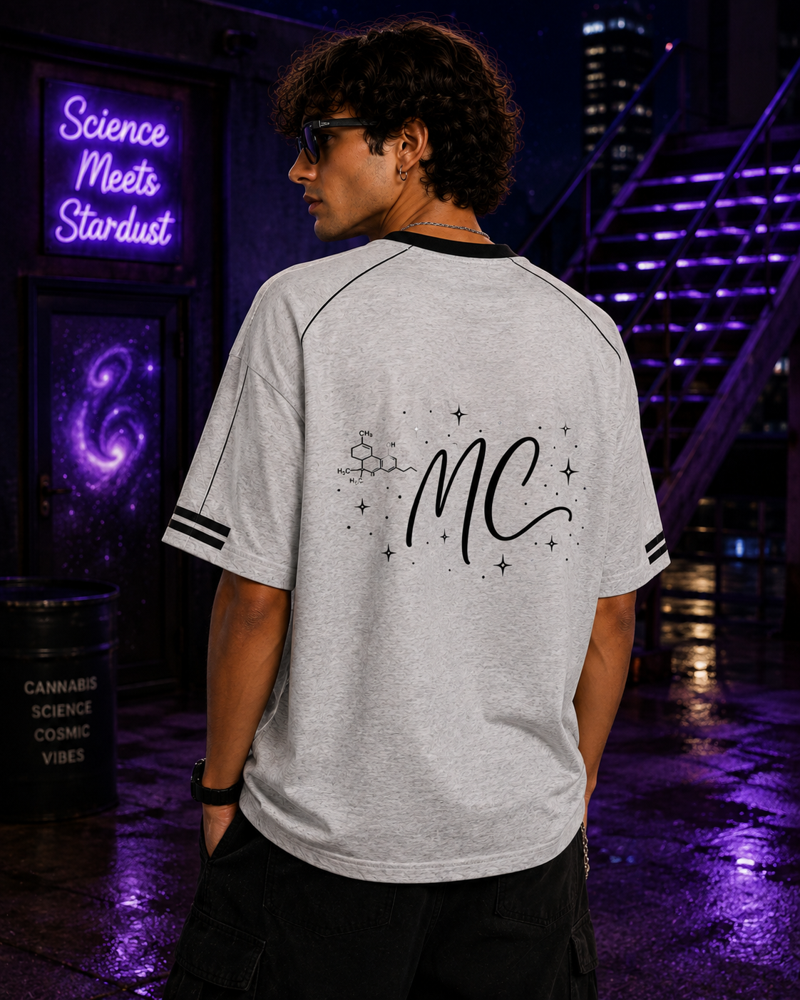 Back lifestyle view of a man wearing the Flower Gray Mandi Cruz Media Signature™ Raglan Tee featuring the MC monogram and molecule artwork.