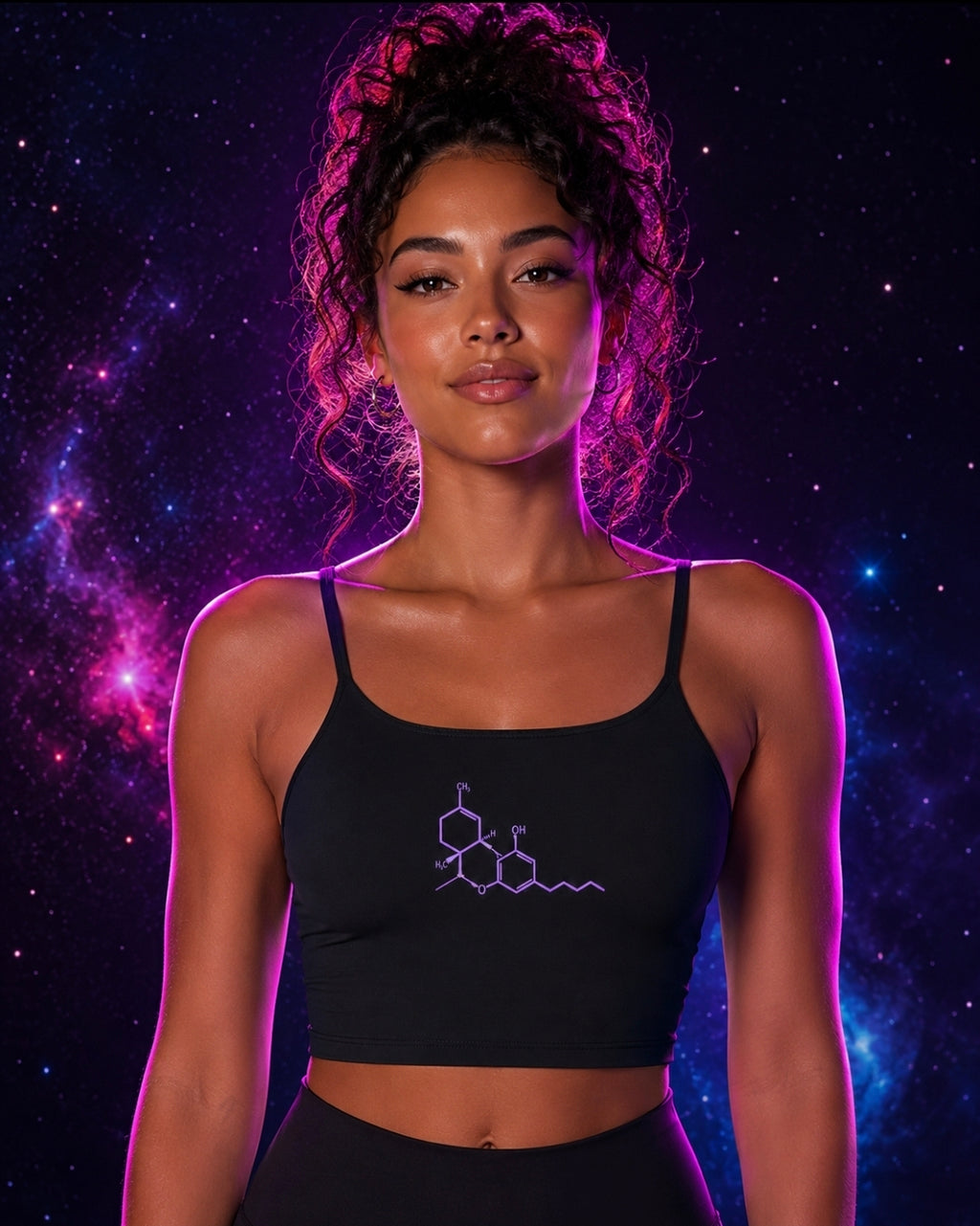 Front lifestyle view of a woman wearing the black Neon THC Molecule Crop Tank featuring a purple THC molecular structure graphic against a pink, purple, and blue galaxy background.