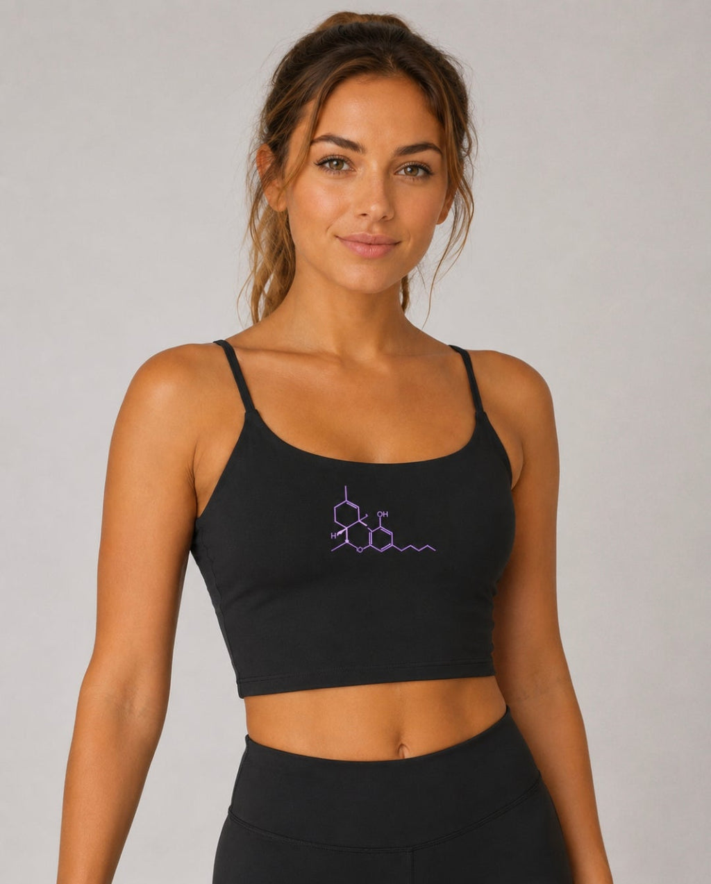 Woman wearing the Neon THC Molecule Crop Tank featuring the science-inspired THC molecular graphic on the front.