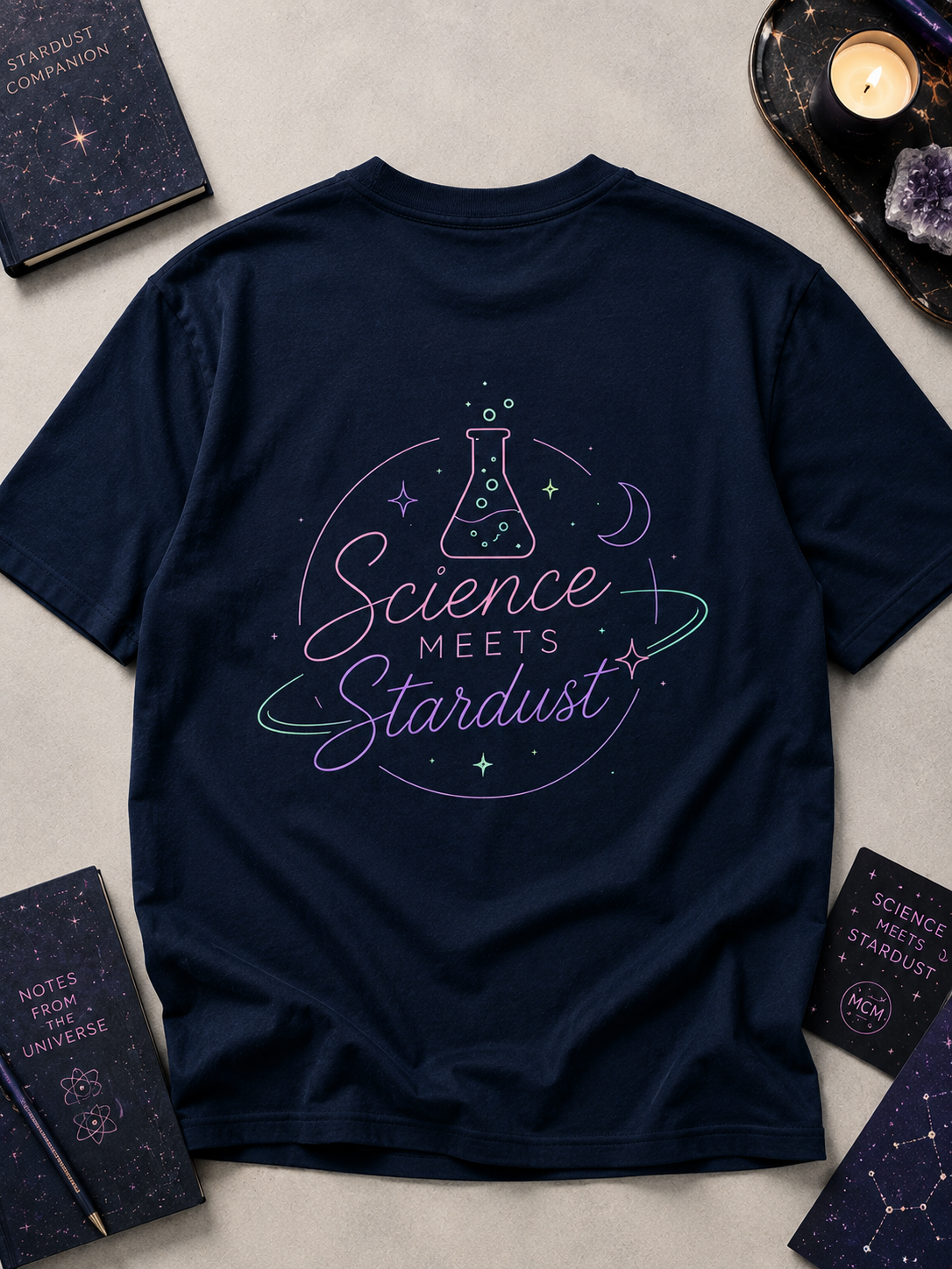 Flat-lay back view of the navy blue Mandi Cruz Media T-shirt featuring the Science Meets Stardust™ beaker and celestial graphic.