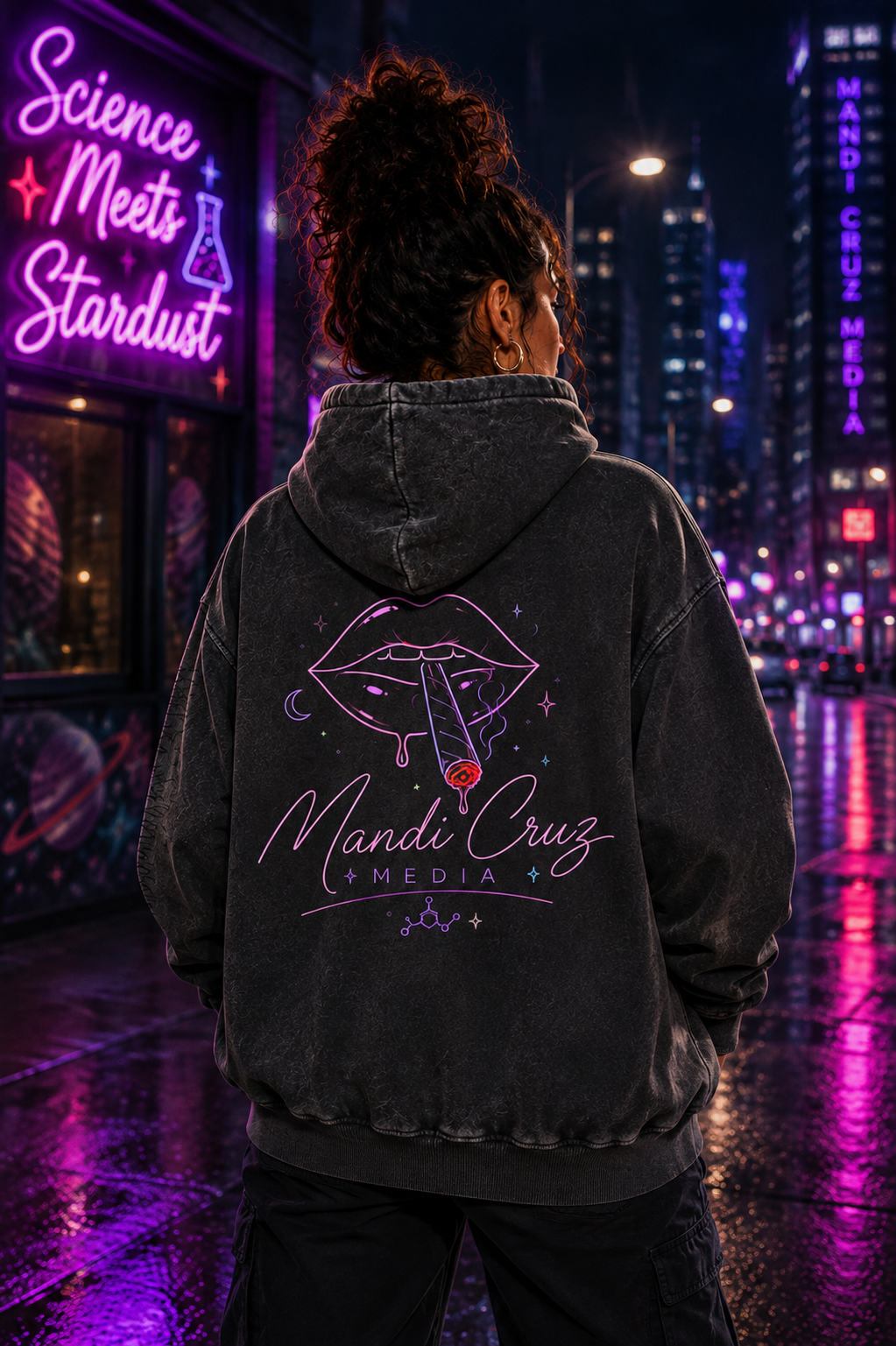 Back lifestyle view of a model wearing the black Mandi Cruz Media Smoker’s Lips™ snow wash oversized hoodie featuring the cosmic lips graphic in a neon city setting.