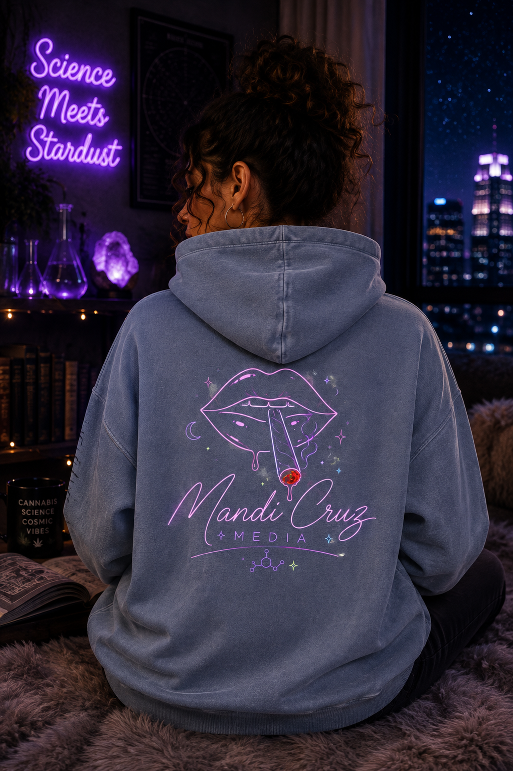 Back lifestyle view of a model wearing the blue Mandi Cruz Media Smoker’s Lips™ snow wash oversized hoodie featuring the cosmic lips graphic and Mandi Cruz Media logo.